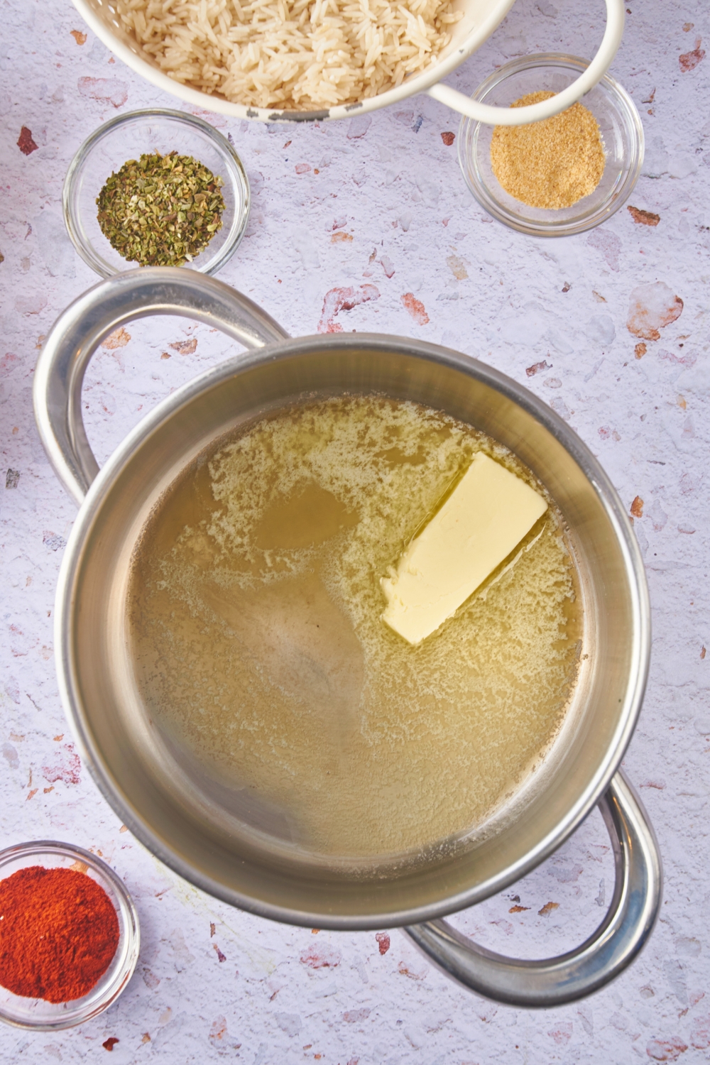 A large pot with a large tab of butter melting in it.