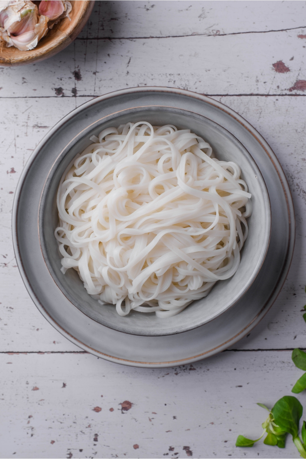 Overhead view of a bowl filled with cooked rice noodles.