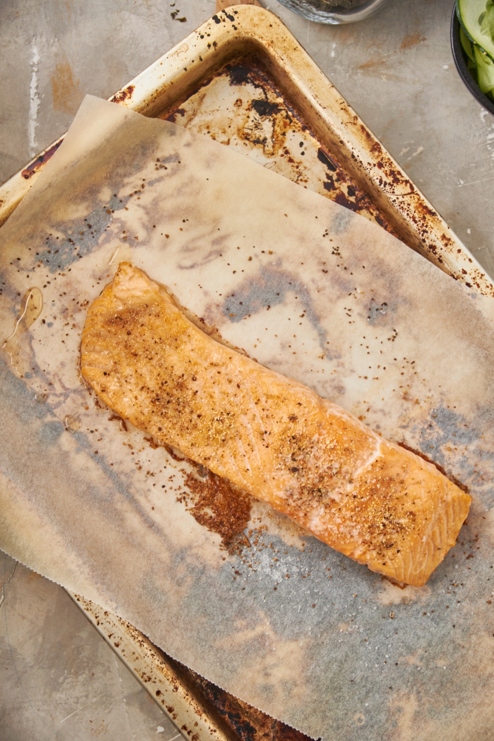 A fillet of baked salmon on a baking sheet lined with parchment paper.