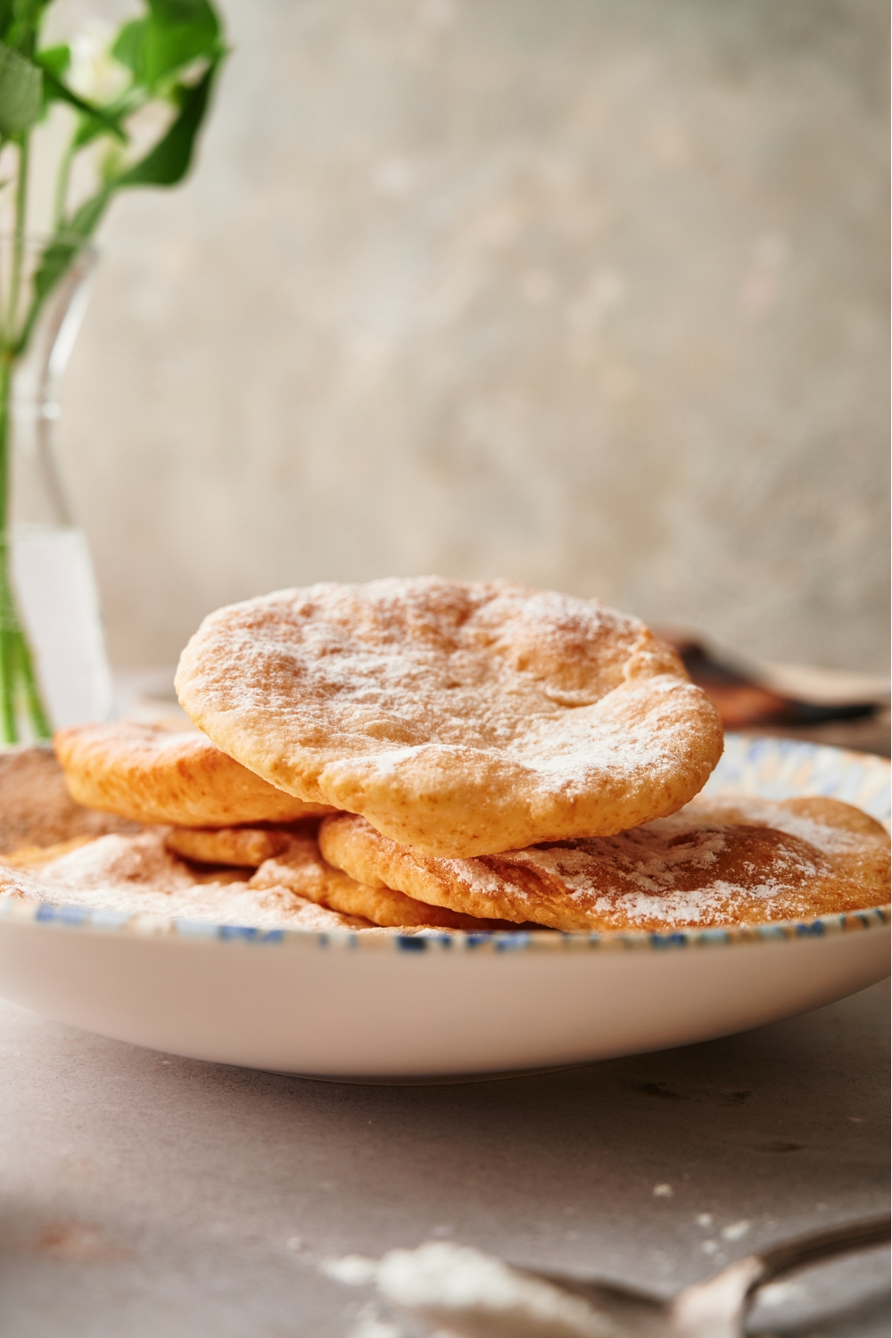 A few pieces of fried dough stacked on a plate.