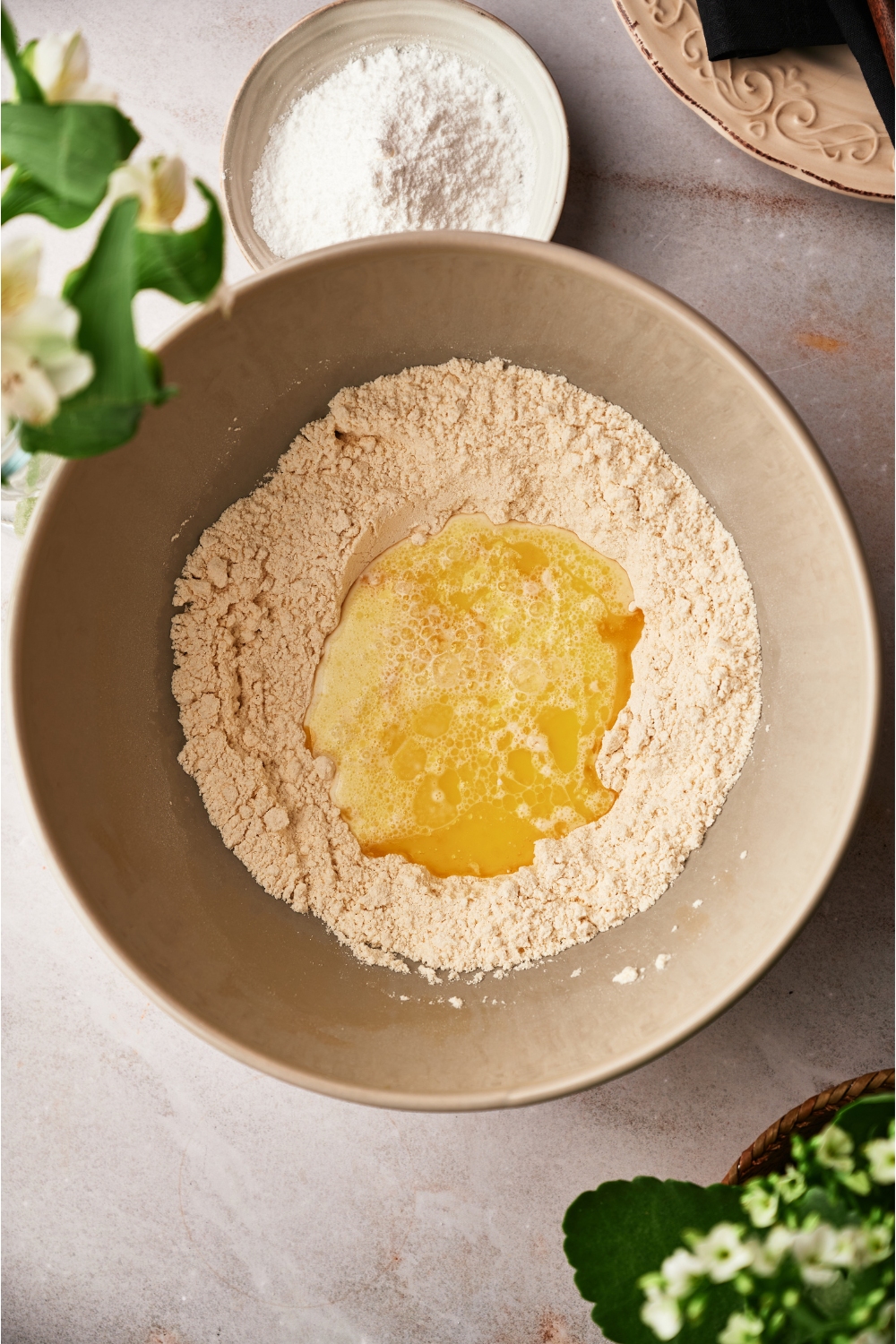 Melted butter in a bowl that is filled with flour.