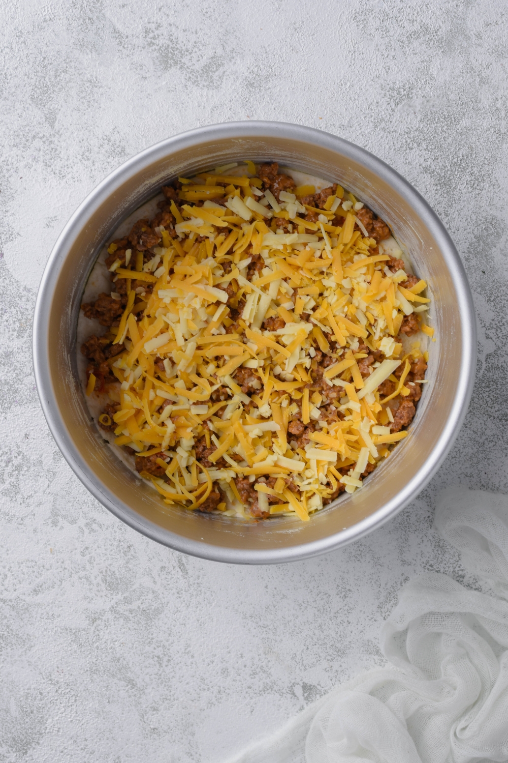 A round pan with unbaked taco casserole in it.