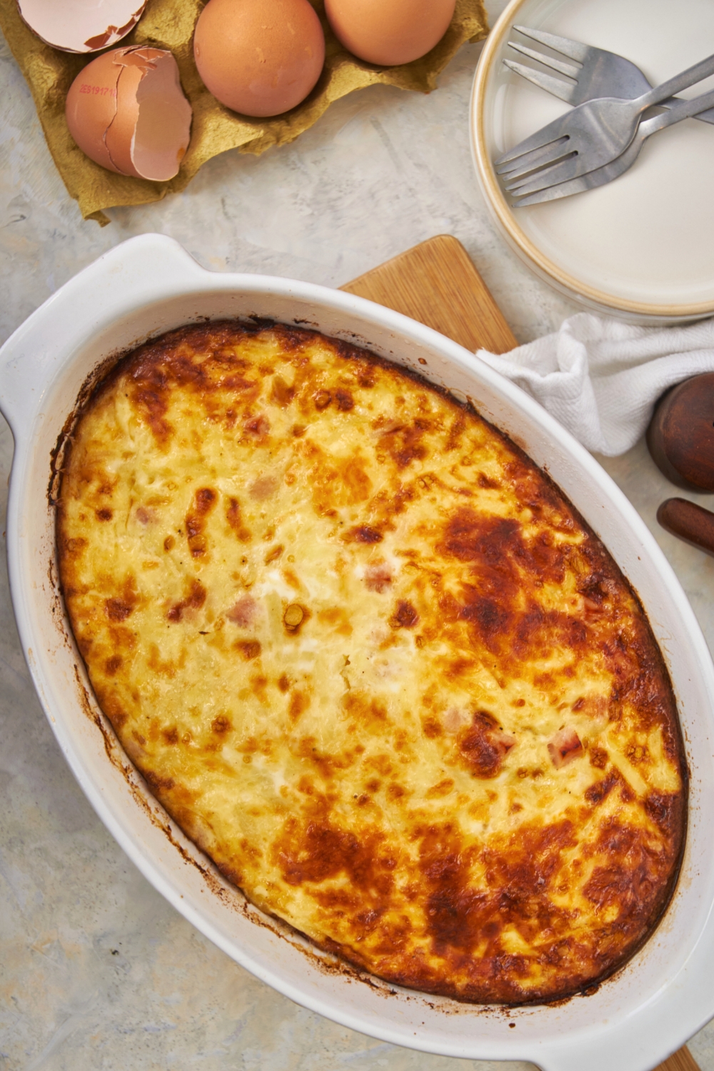 A breakfast casserole with ham and cheese in a casserole dish.
