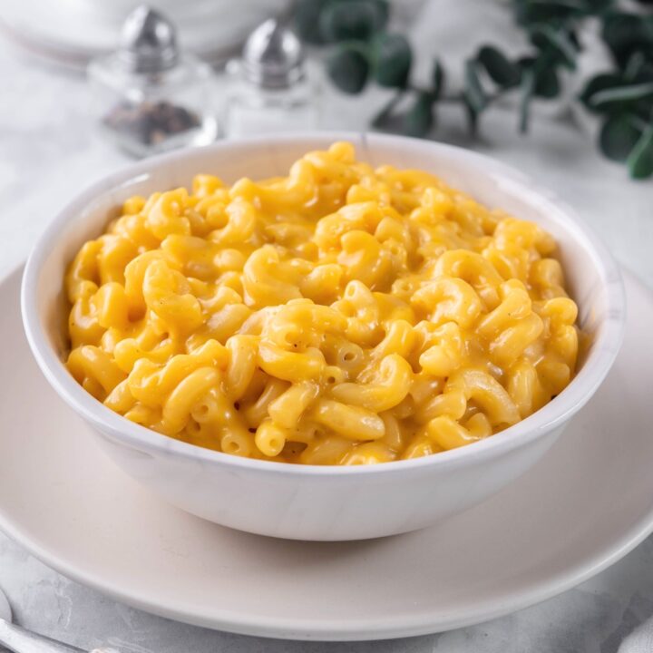 A bowl of mac and cheese on a white plate.