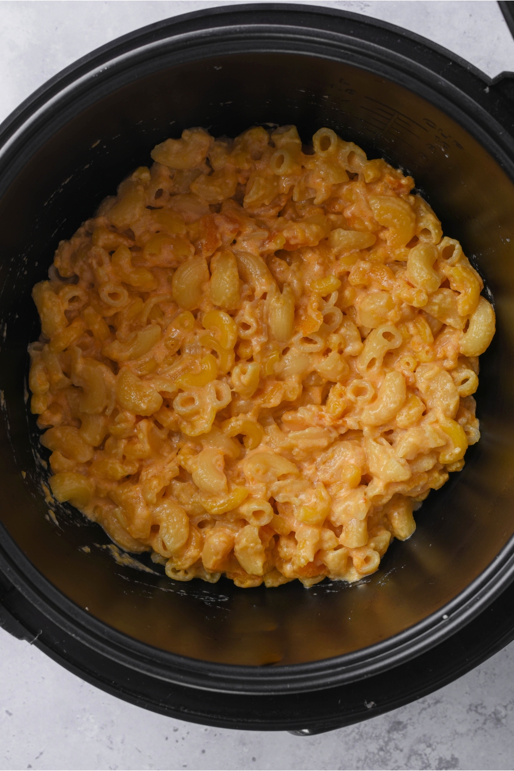 A crockpot with cooked mac and cheese.