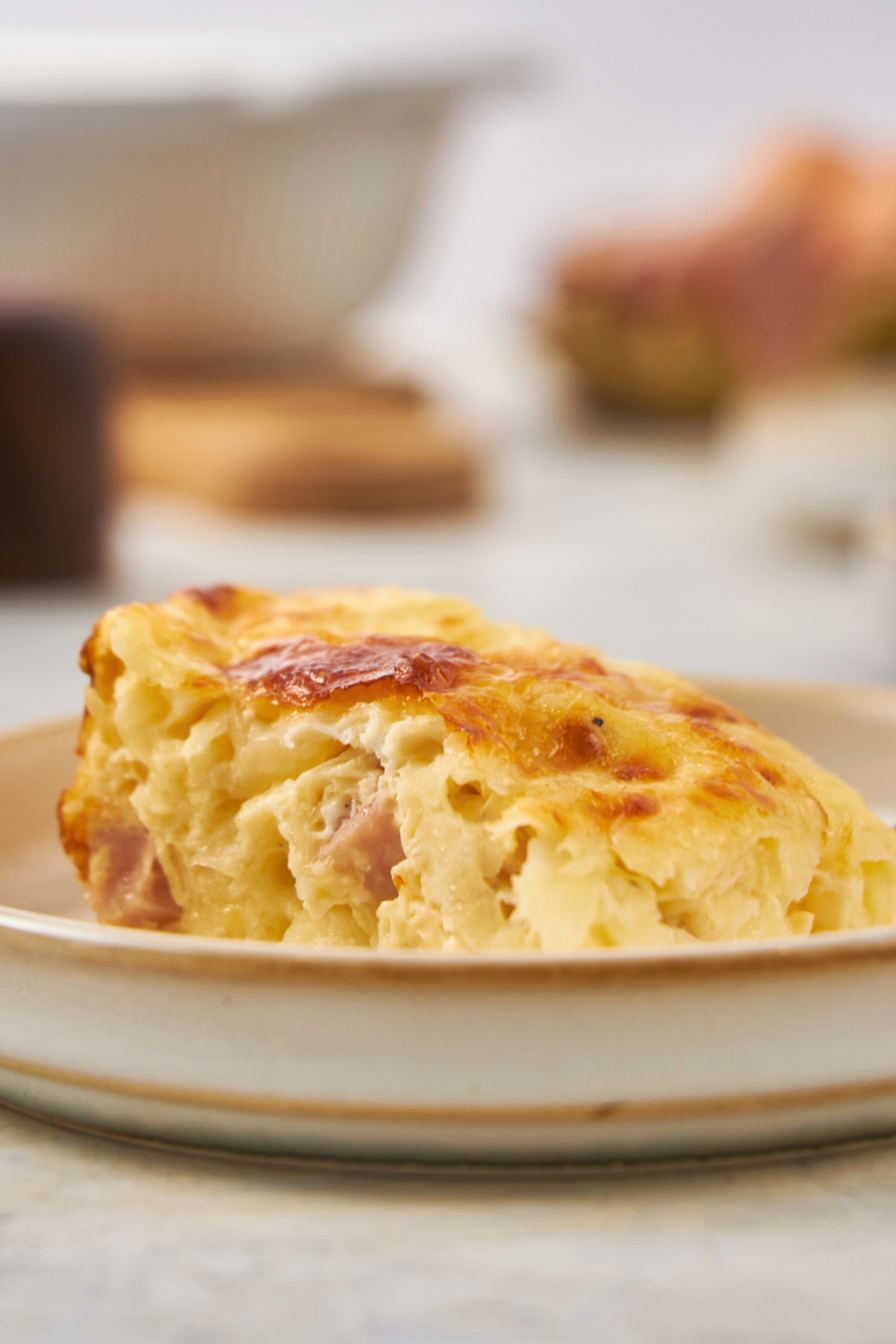 A piece of ham and cheese breakfast casserole on a plate.