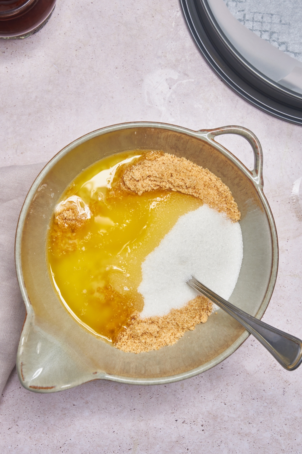 A mixing bowl with sugar, graham cracker crumbs, and melted butter.