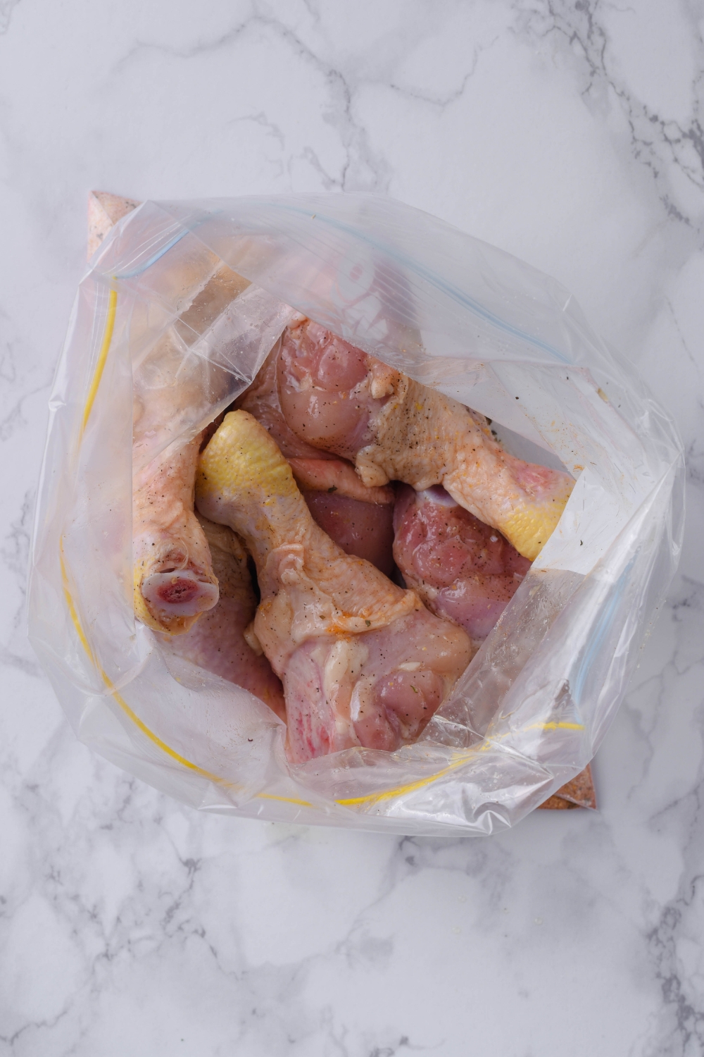 A ziploc with the shake and bake breading; the oiled chicken legs have just been added.