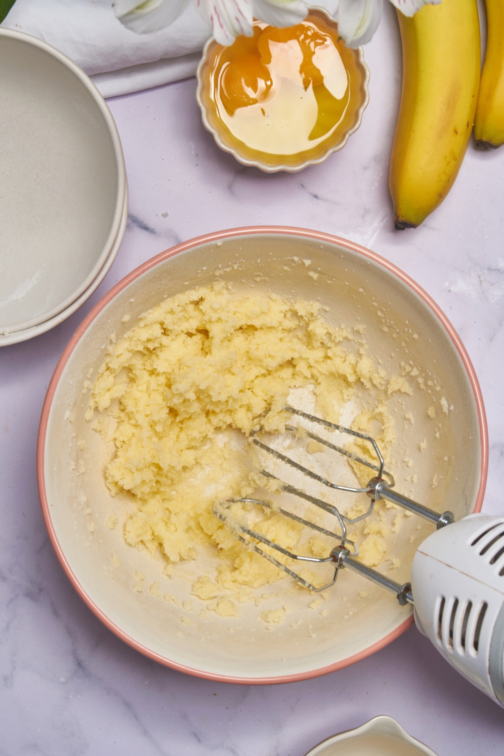 A mixing bowl with creamed butter and sugar.