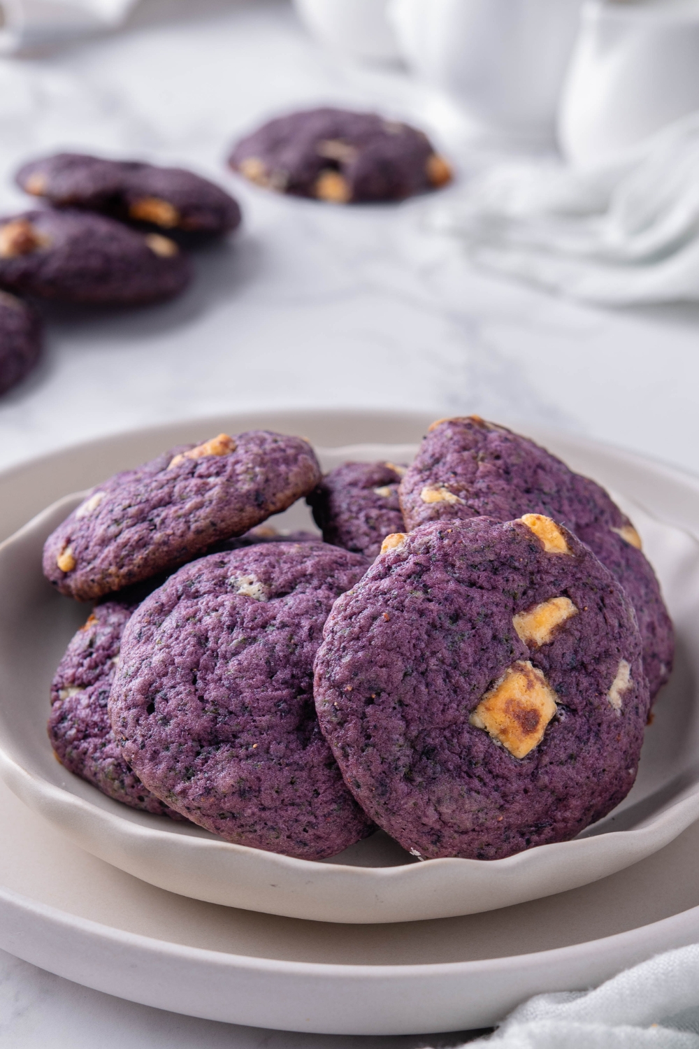 A plate with a pile of blueberry cookies.