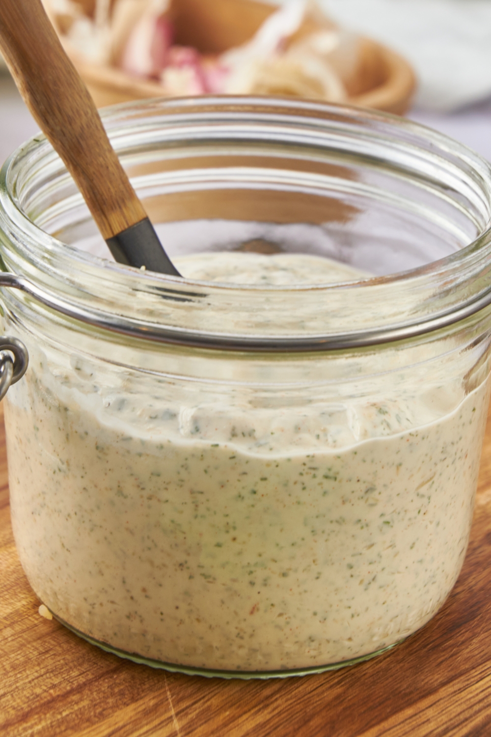 A mason jar with homemade ranch dressing in it.