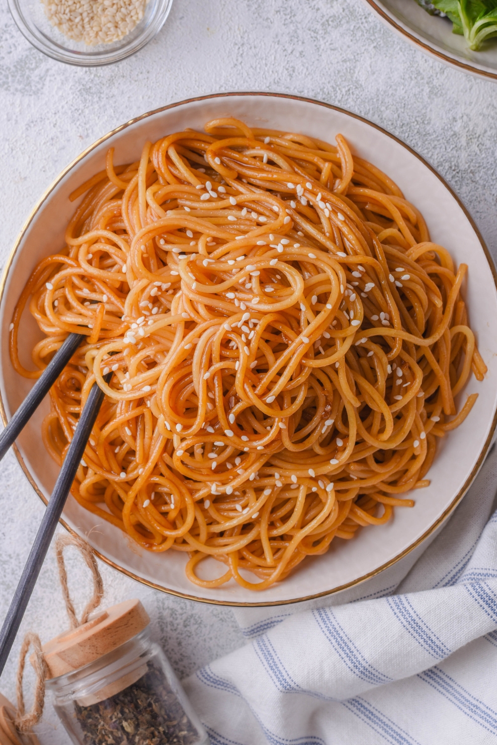 A bowl with hibachi noodles and a pair of chopsticks in the bowl.