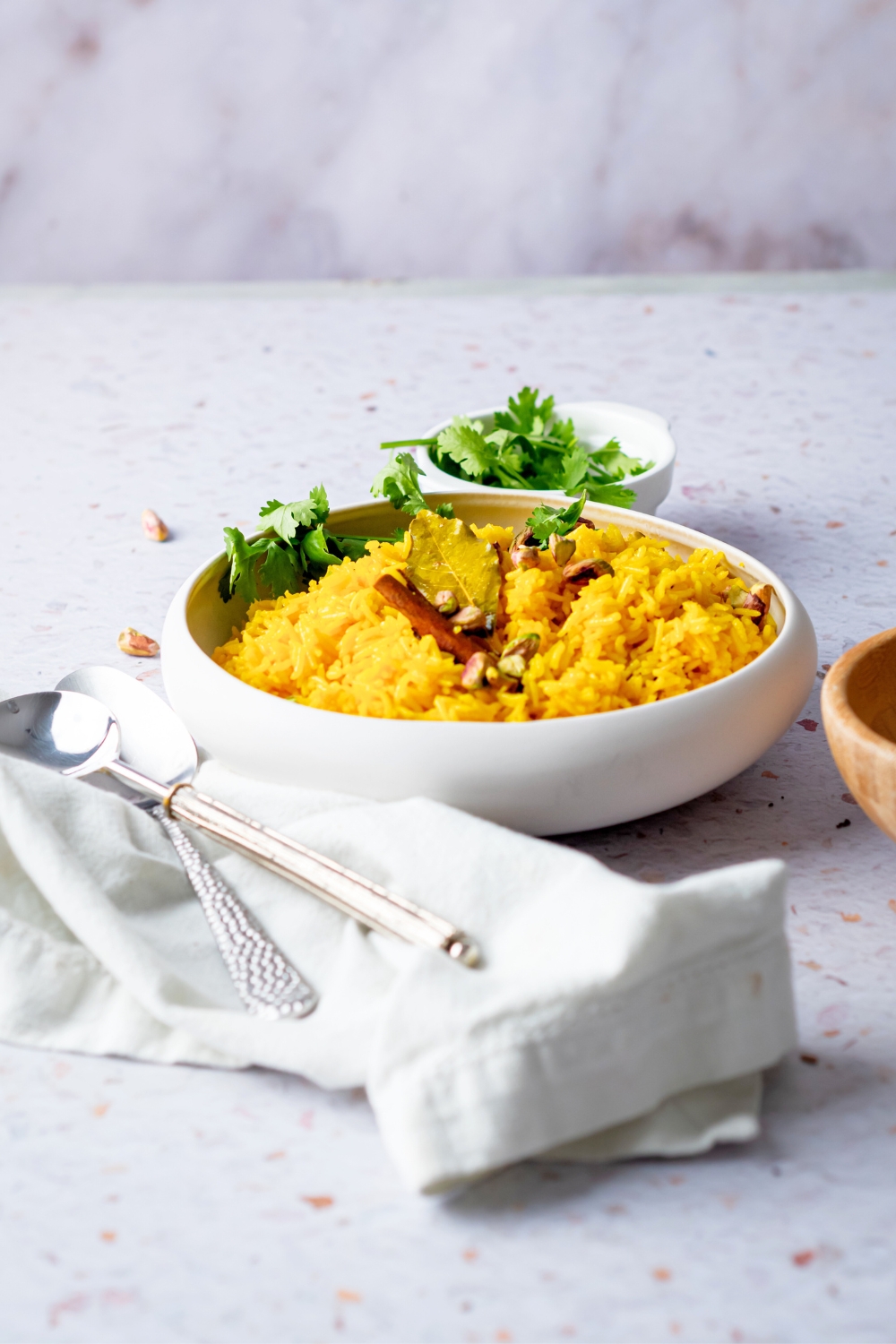 A white bowl that is filled with turmeric rice.