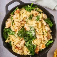 A skillet filled with chicken broccoli alfredo.