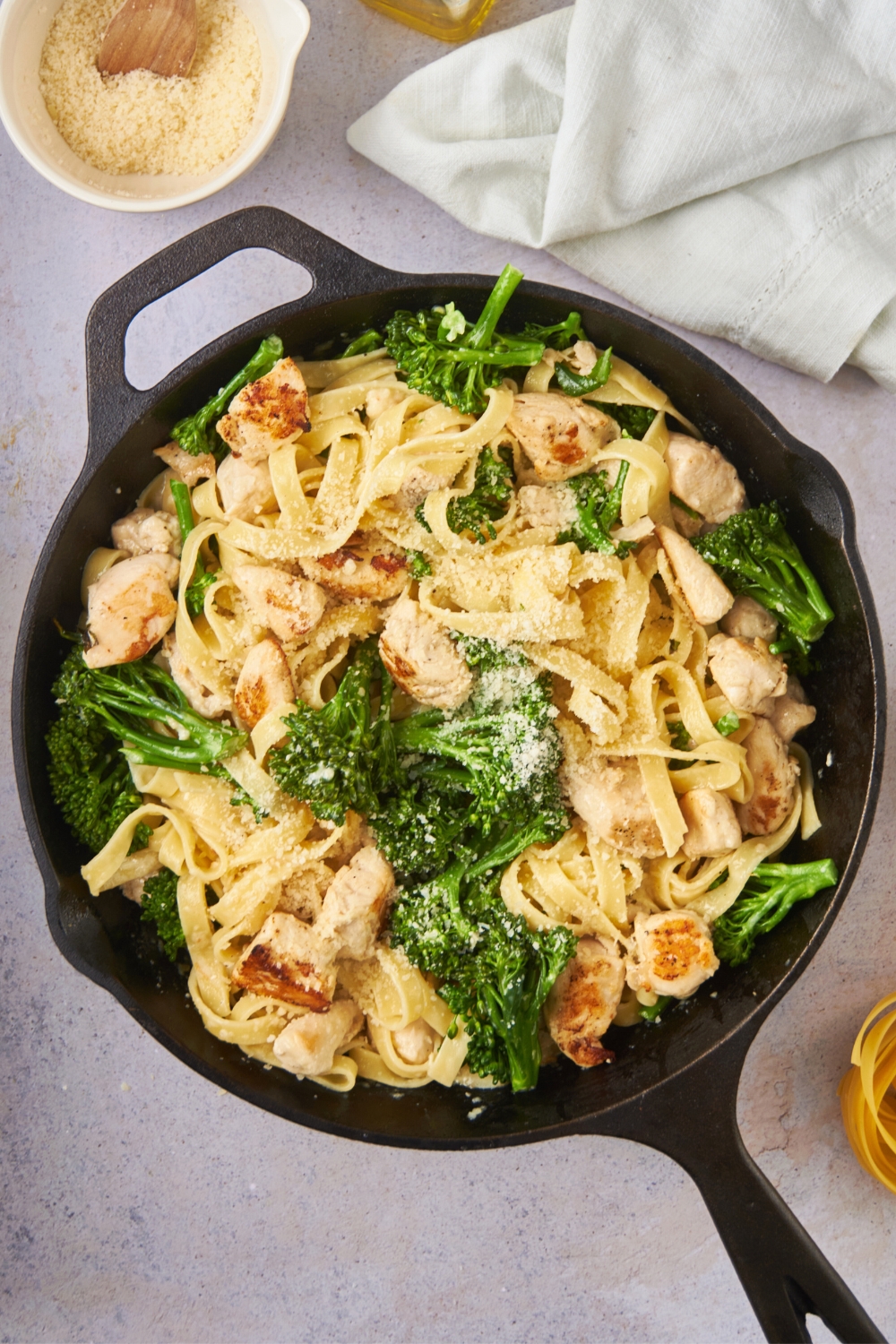 A skillet filled with chicken broccoli alfredo.