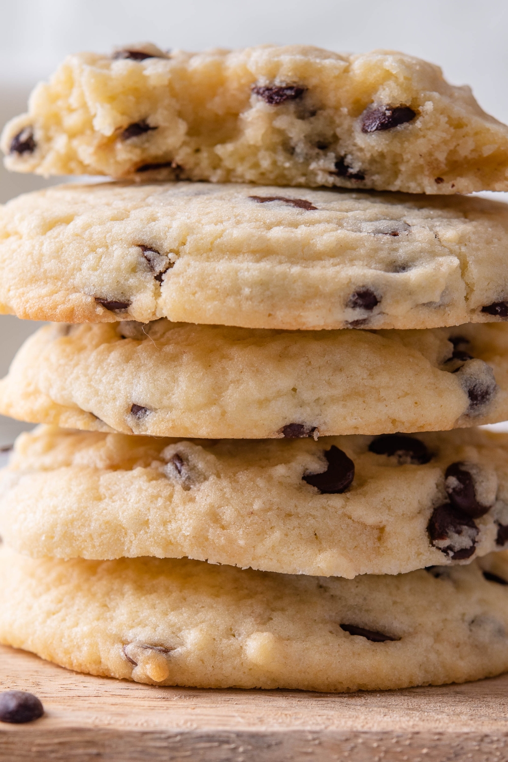 A stack of chocolate chip cookies with one cookie split in half on top.