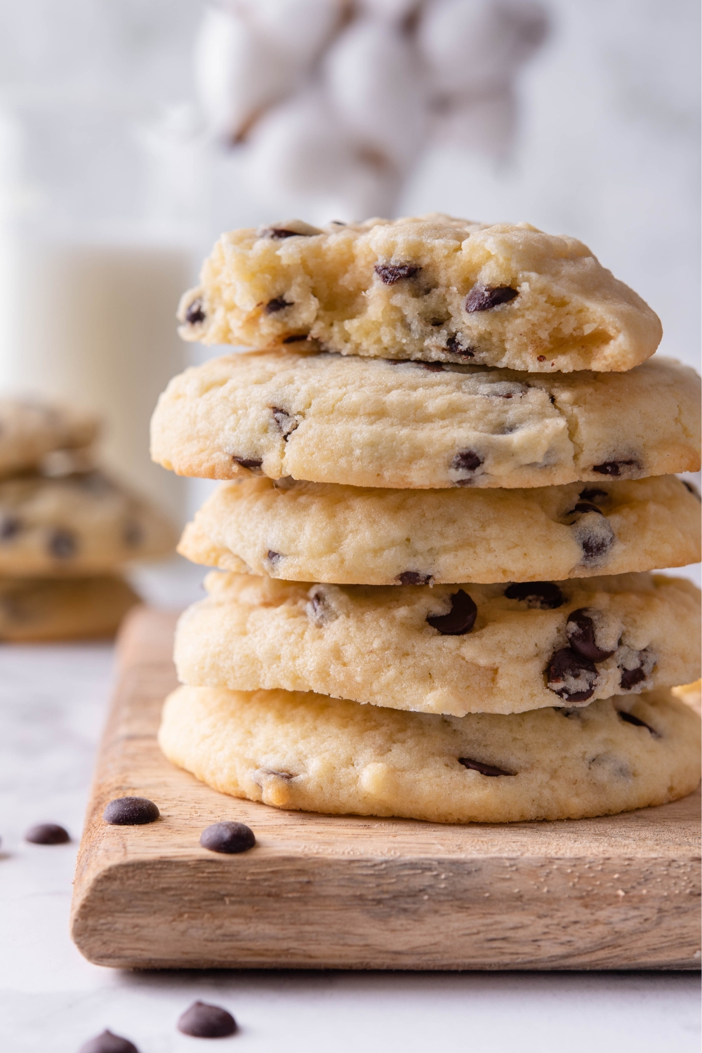 A stack of chocolate chip cookies with one cookie split in half on top.