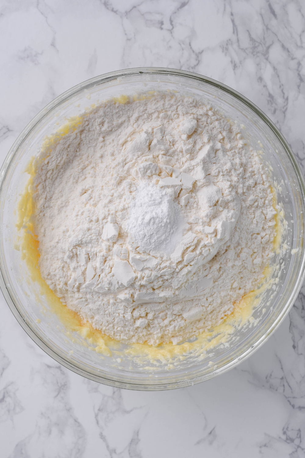 A mixing bowl with the dry ingredients being added to the wet ingredients.