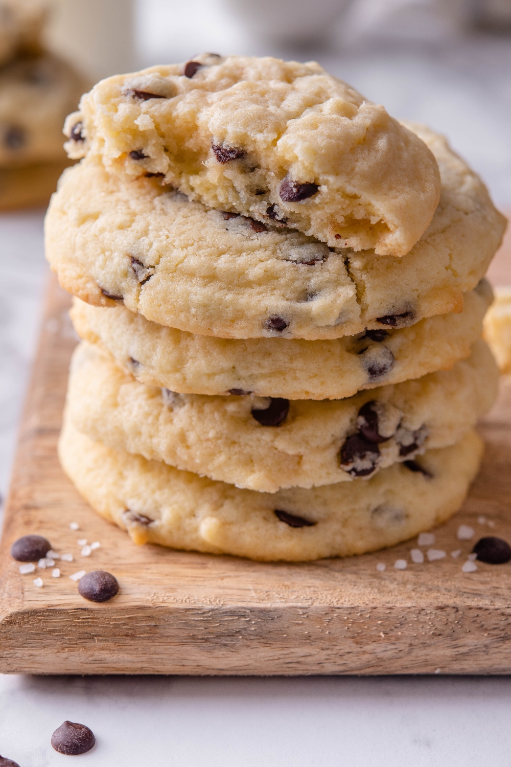 A stack of chocolate chip cookies with one cookie split in half on top.