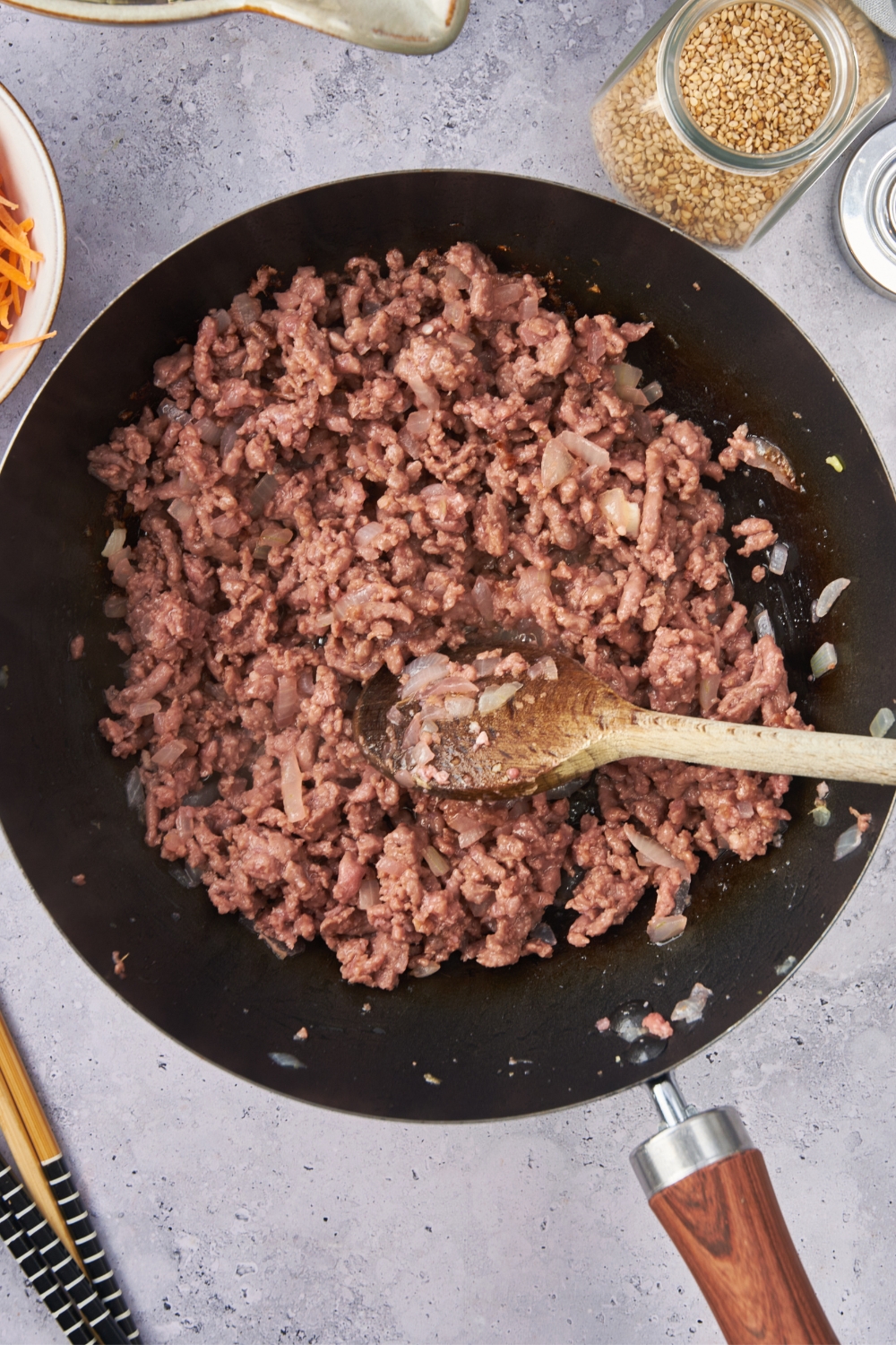 A skillet with ground beef cooking.