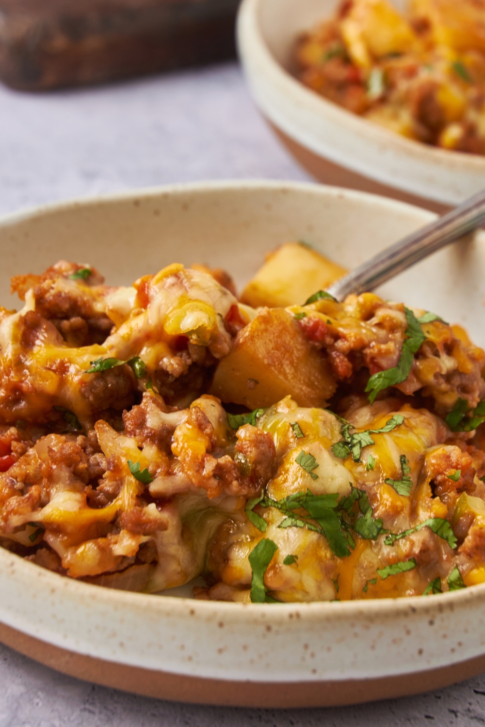 A bowl with a portion of taco potato casserole.