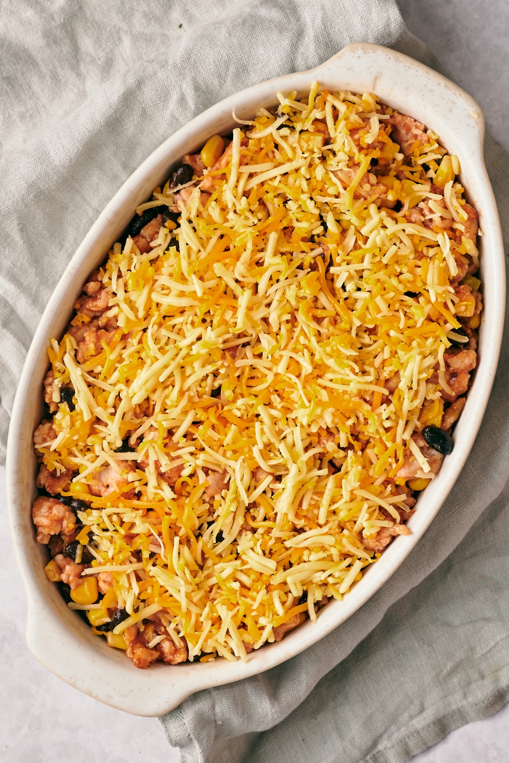 A casserole dish with unbaked taco rice casserole.