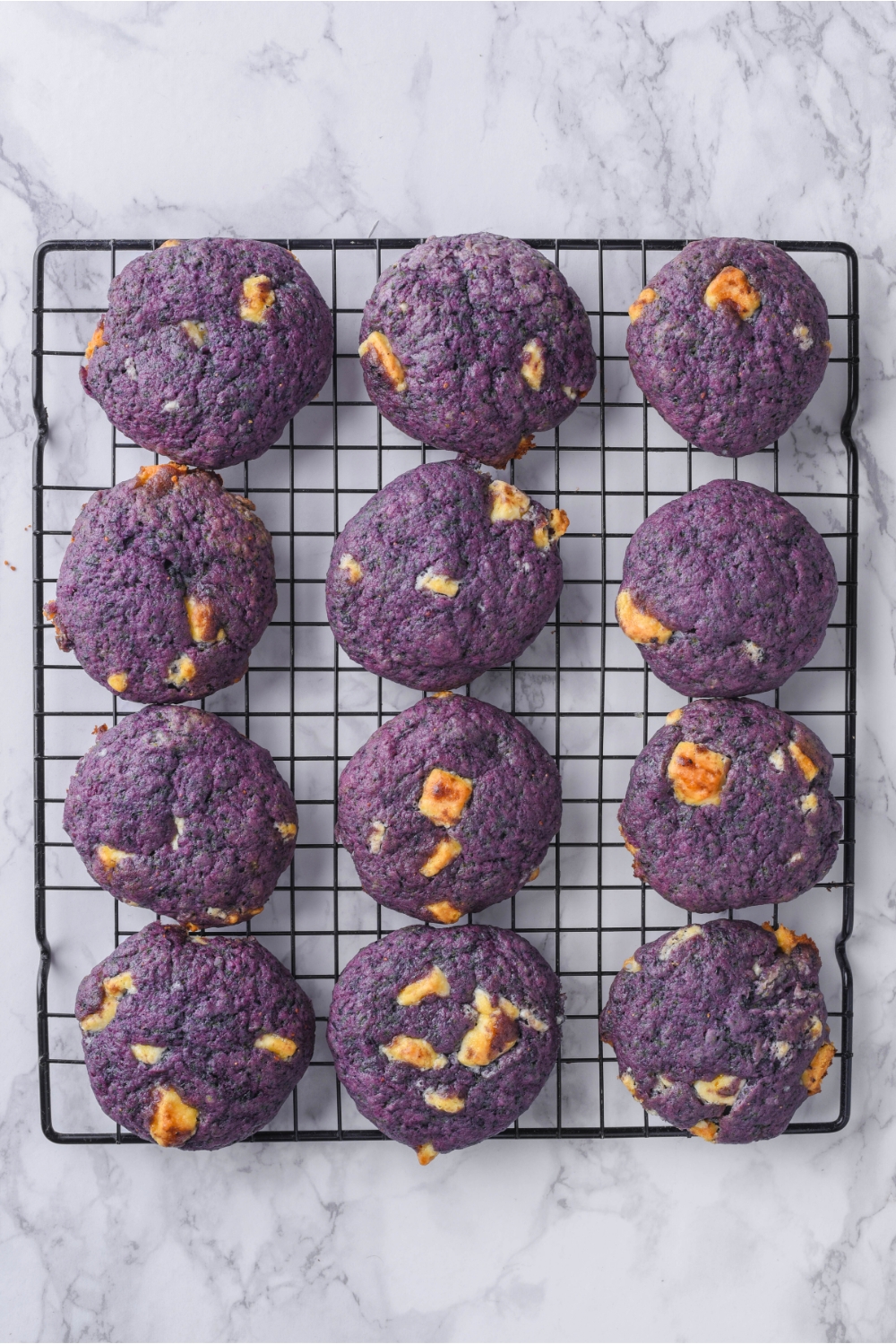 A wire rack with blueberry cookies cooling.
