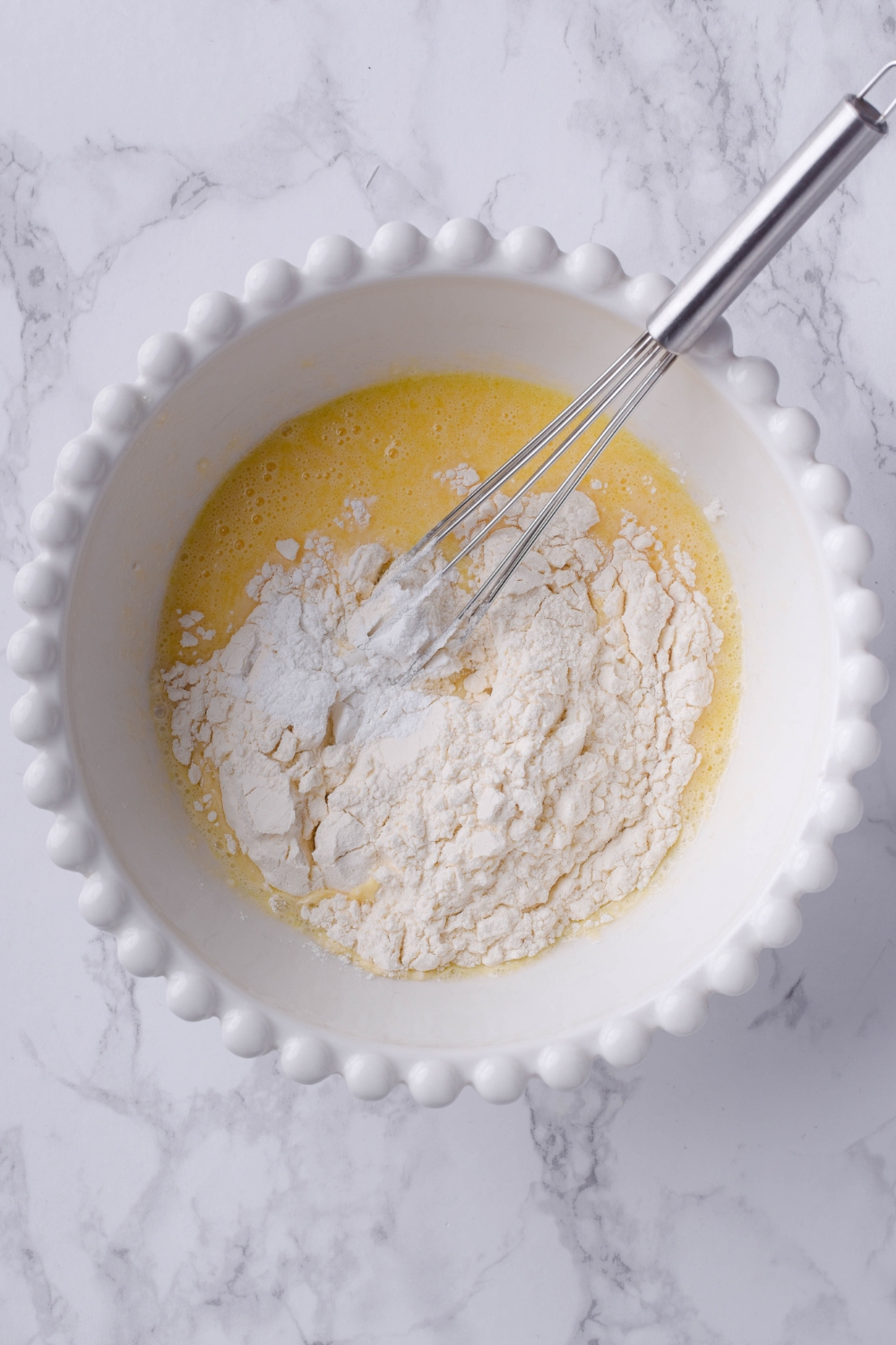 A mixing bowl with wet ingredients and dry ingredients added.