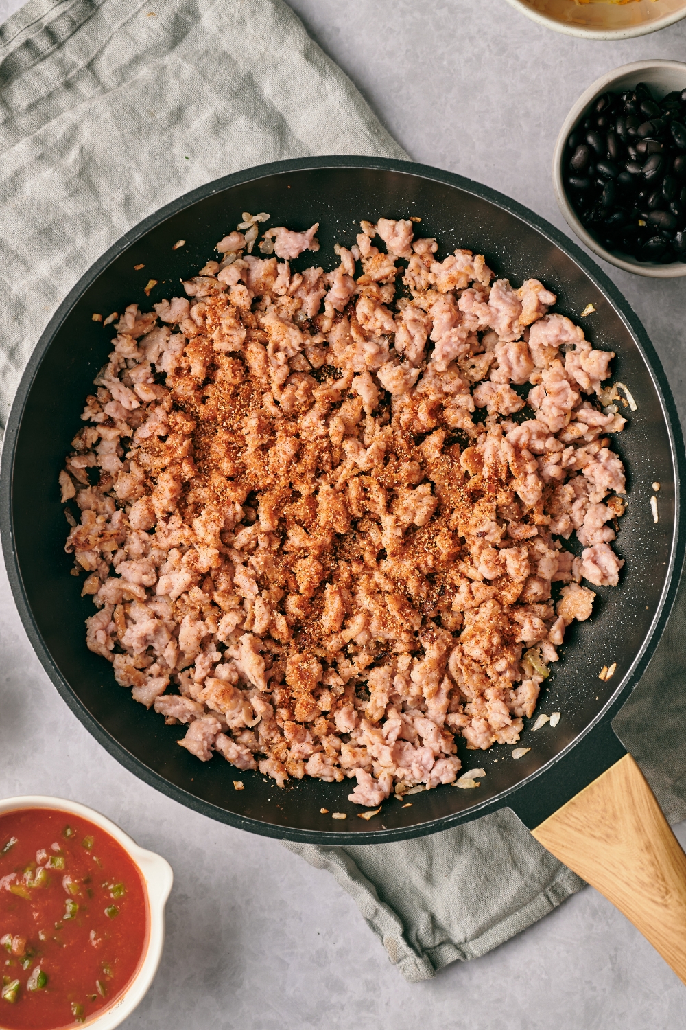 A large skillet with ground beef cooking with taco seasoning.
