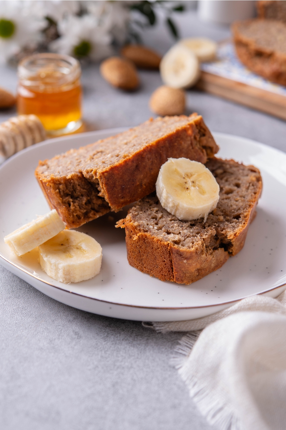 A plate with two slices of cake mix banana bread garnished with a sliced banana bread.