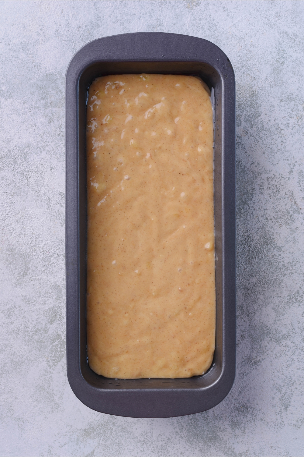 A loaf pan filled with bread batter.