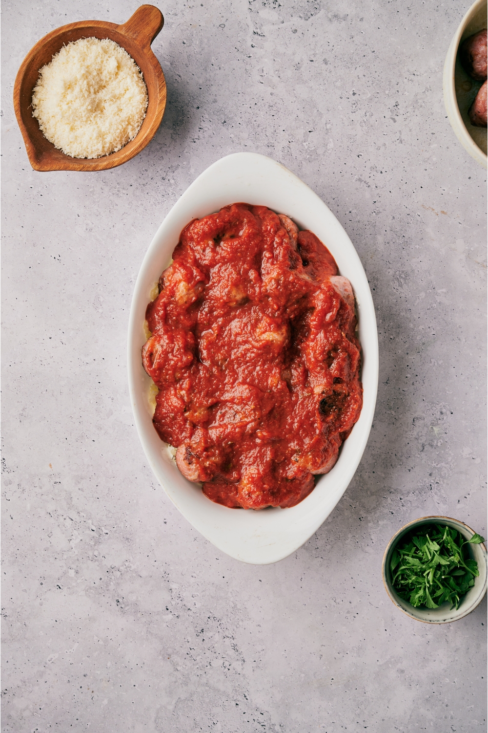 An oval baking dish filled with meatballs covered in red sauce.