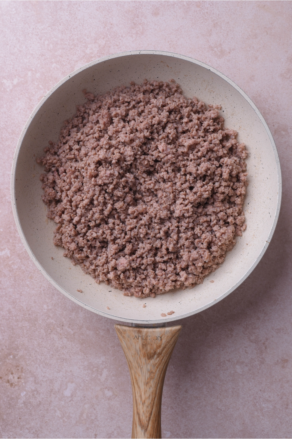 A grey skillet filled with cooked ground beef.