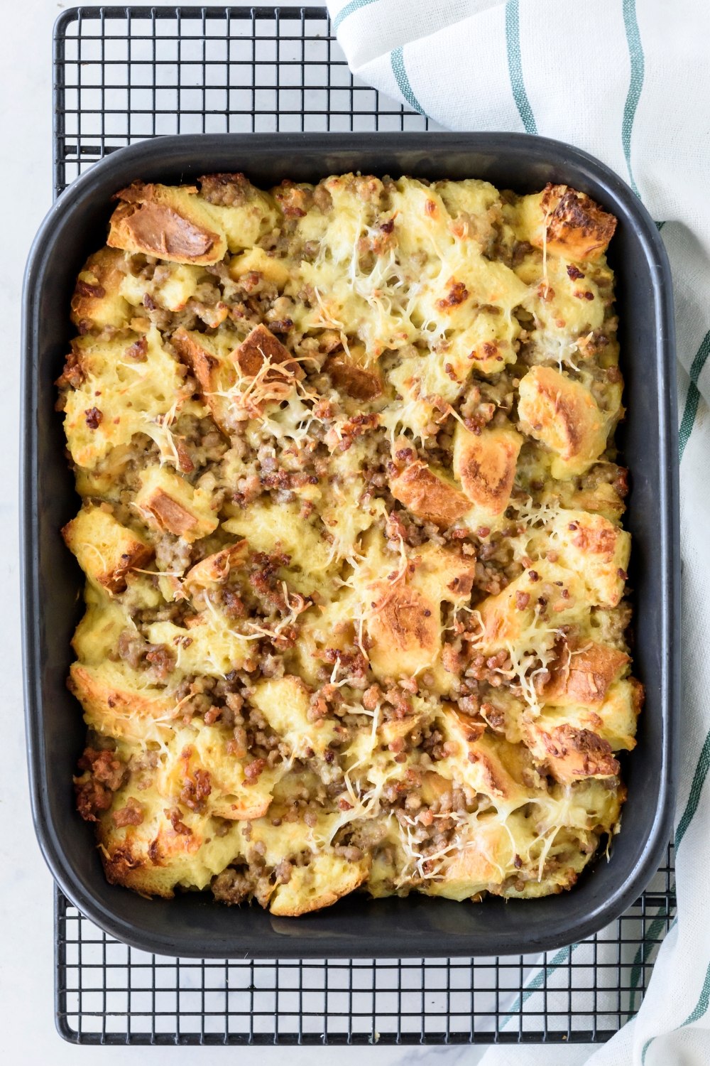 A baking dish filled with freshly baked breakfast casserole that's resting on a cooling rack.