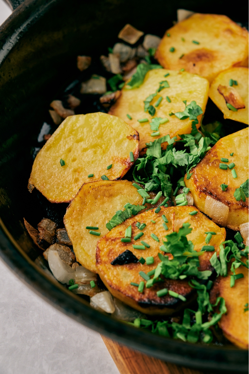 Pan fried potatoes and onions garnished with fresh green herbs.