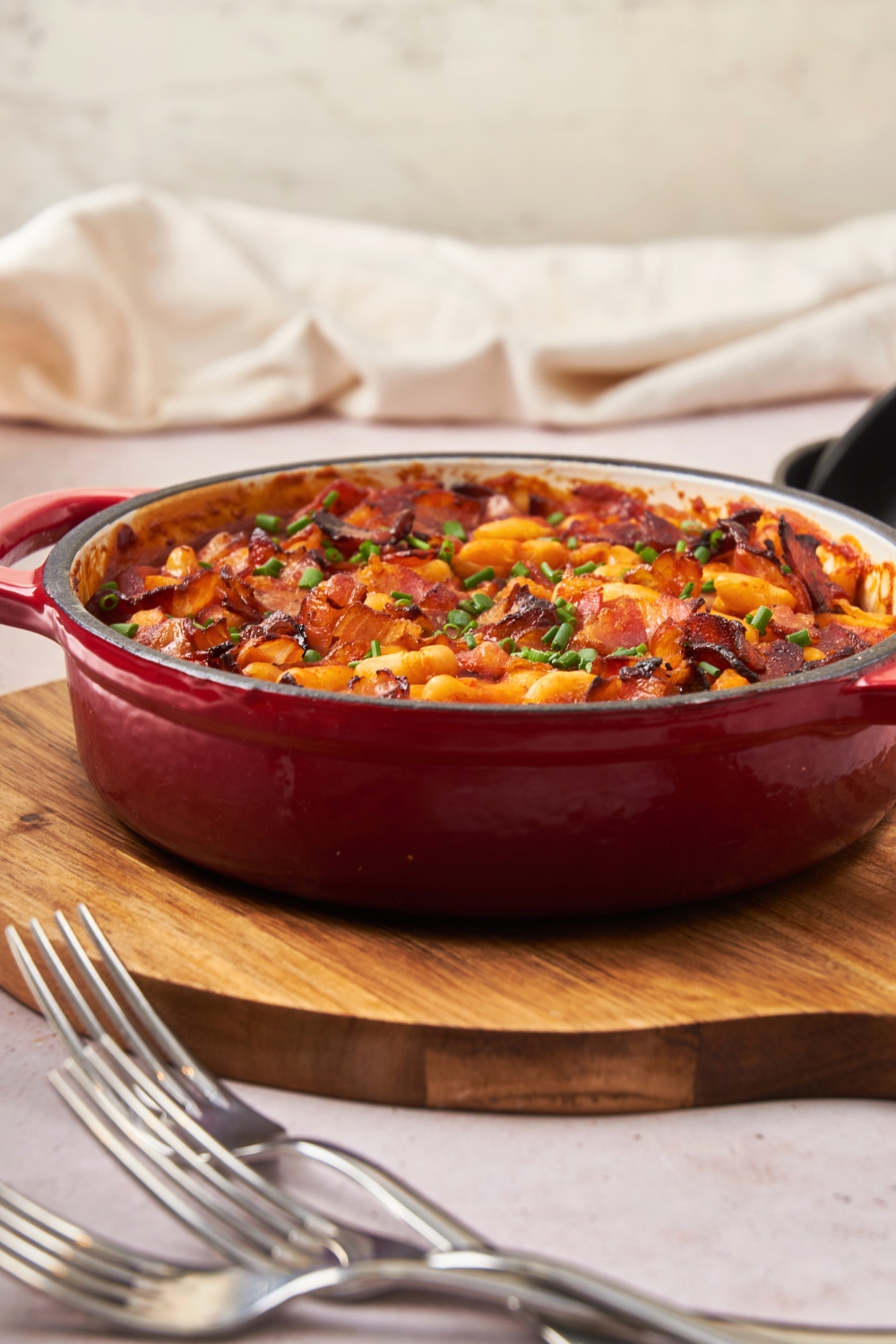 A round baking dish that is filled with baked bean casserole.