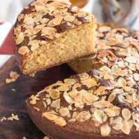 Close up of a honey cake with a slice being taken out.