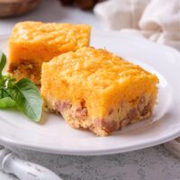 Two squares of Bisquick breakfast casserole with sausage on a white plate.