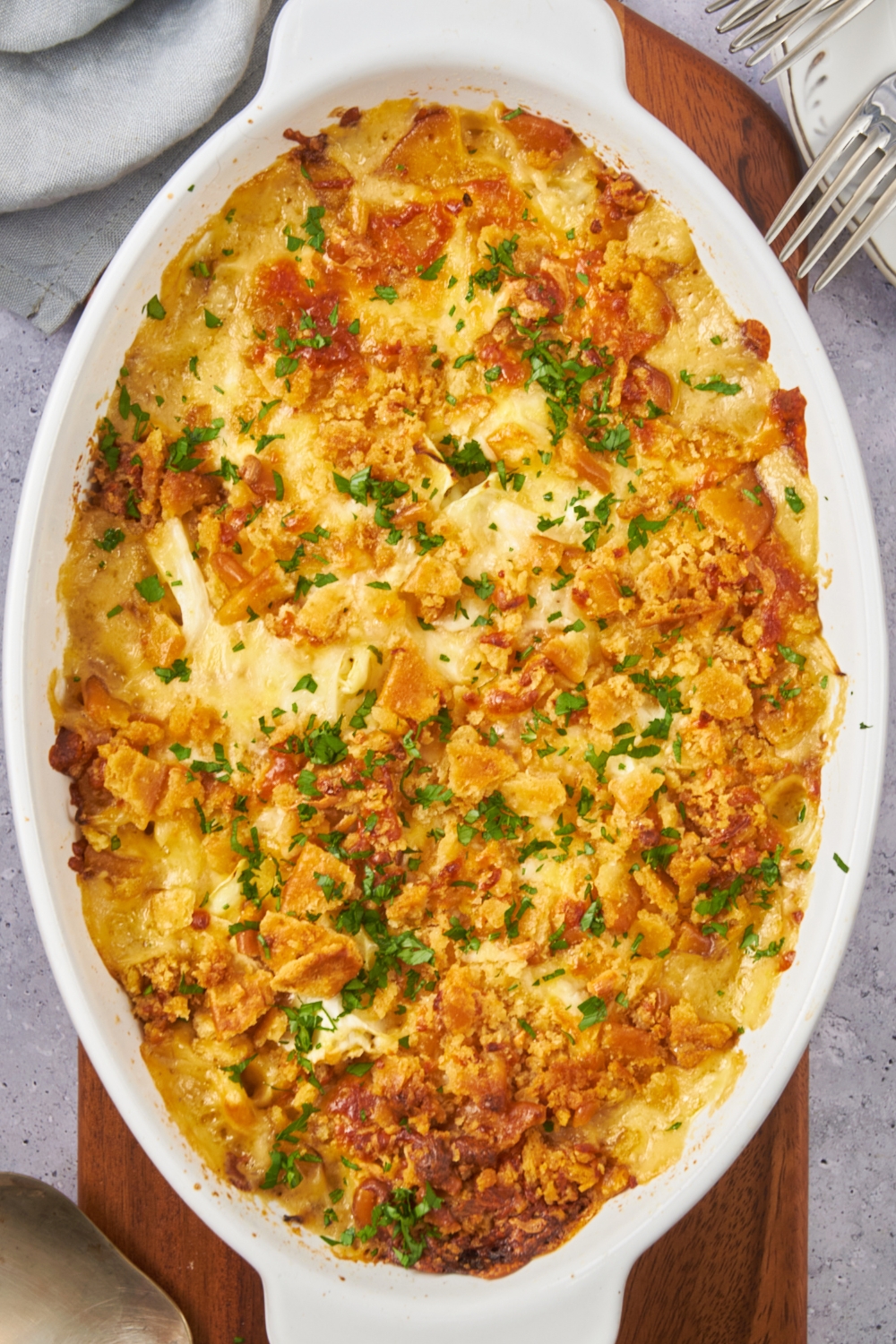 A wooden serving board with a casserole dish full of cabbage casserole.