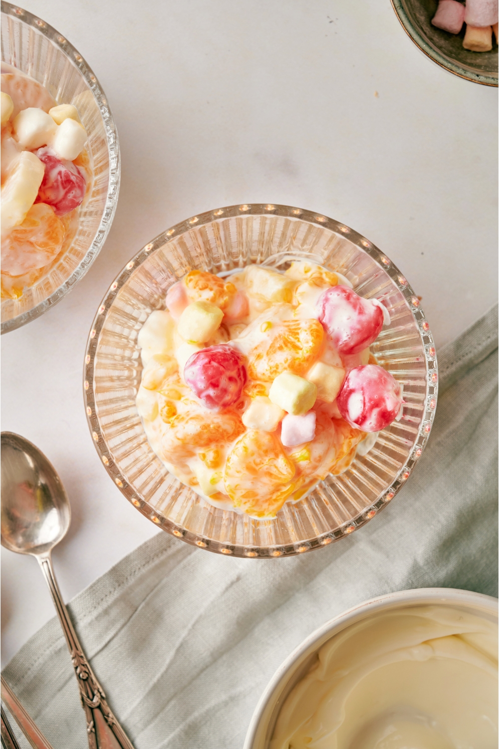 Fruit salad in a glass bowl on a grey counter.