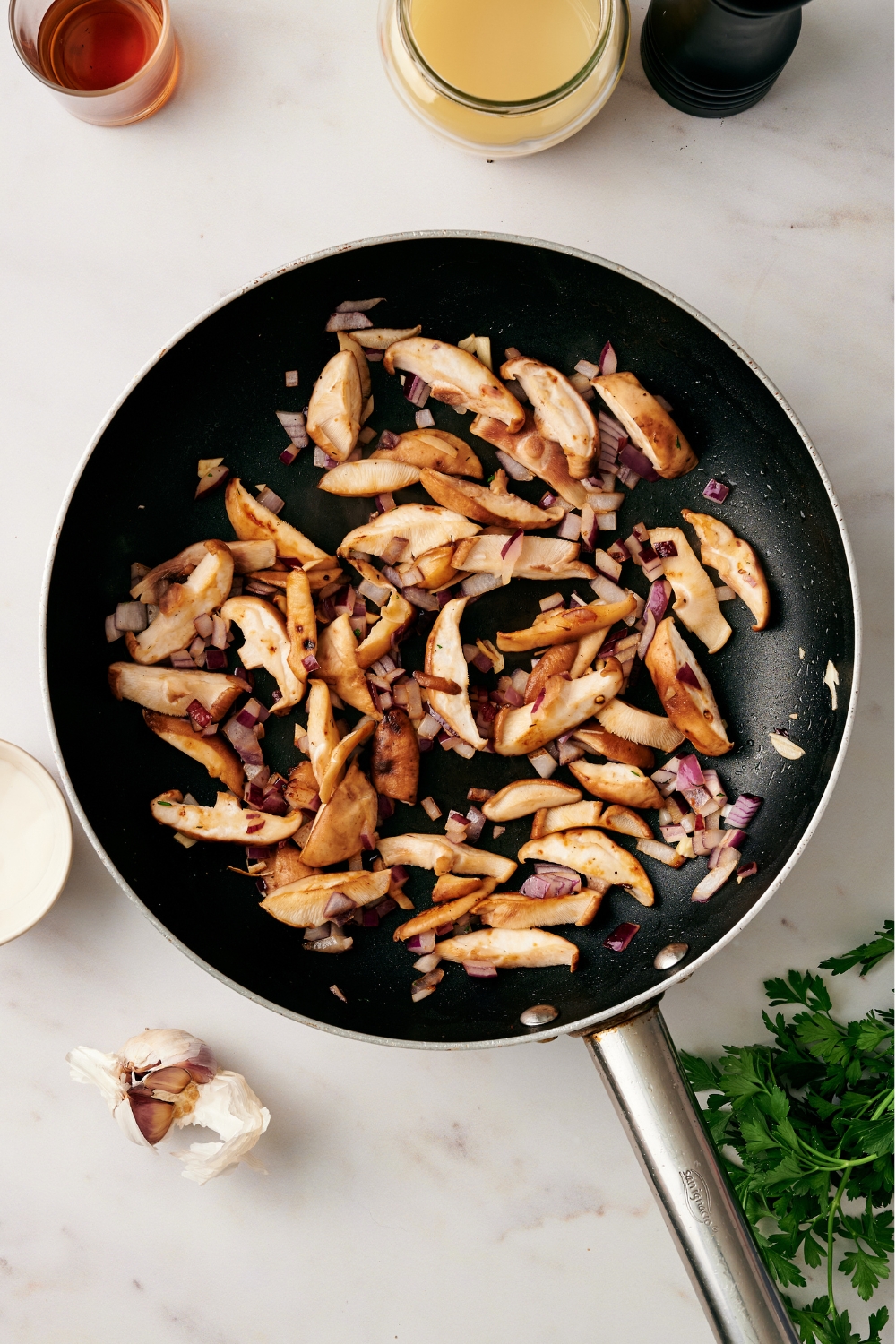 A skillet with cooked mushrooms and onions.