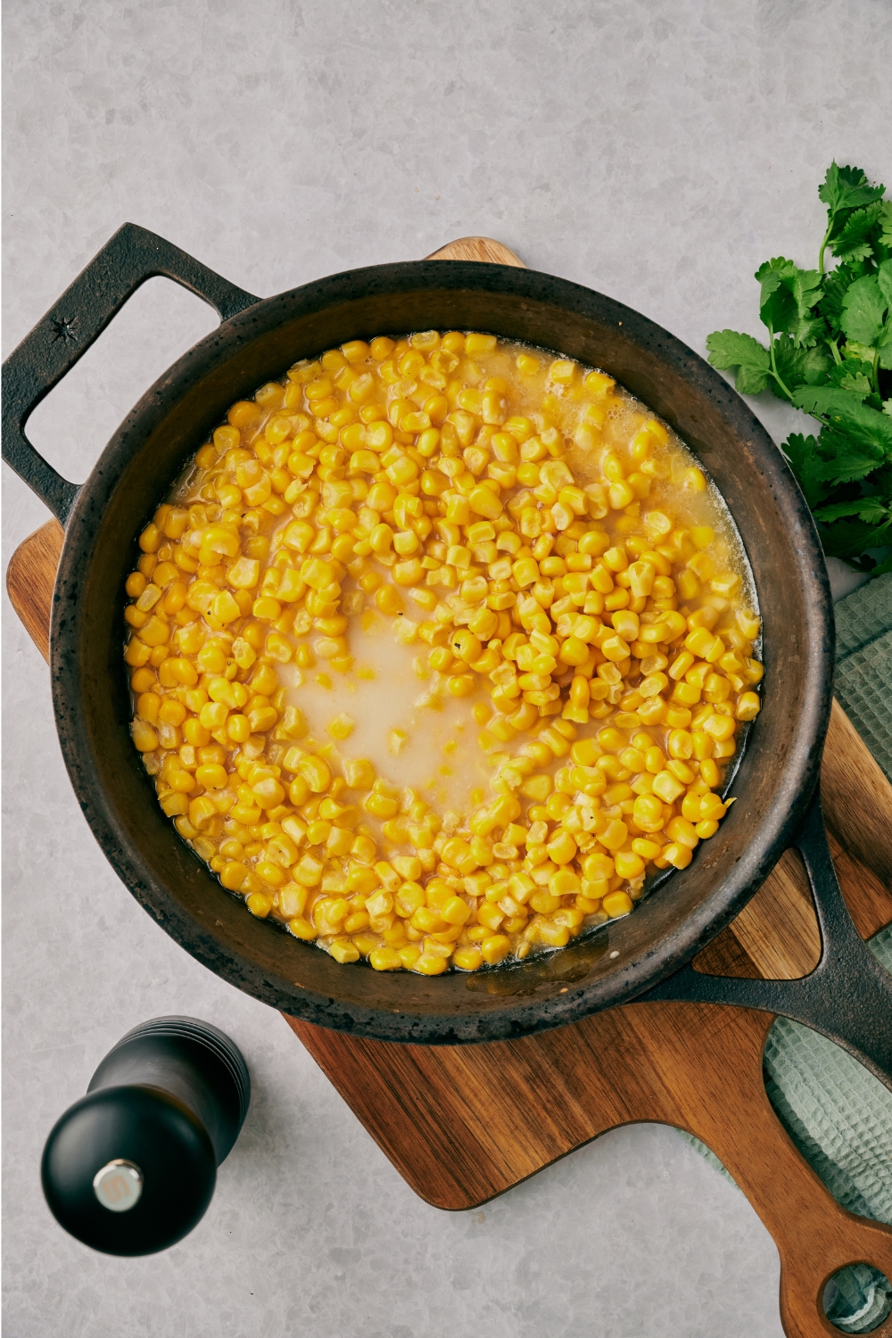 A cast iron skillet with fried corn being cooked.