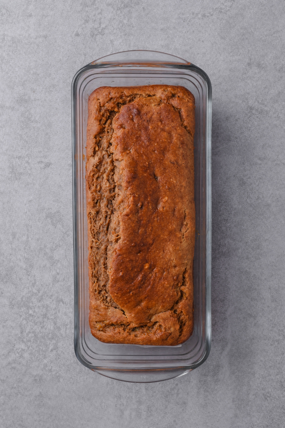 A loaf pan with golden brown cake mix banana bread.