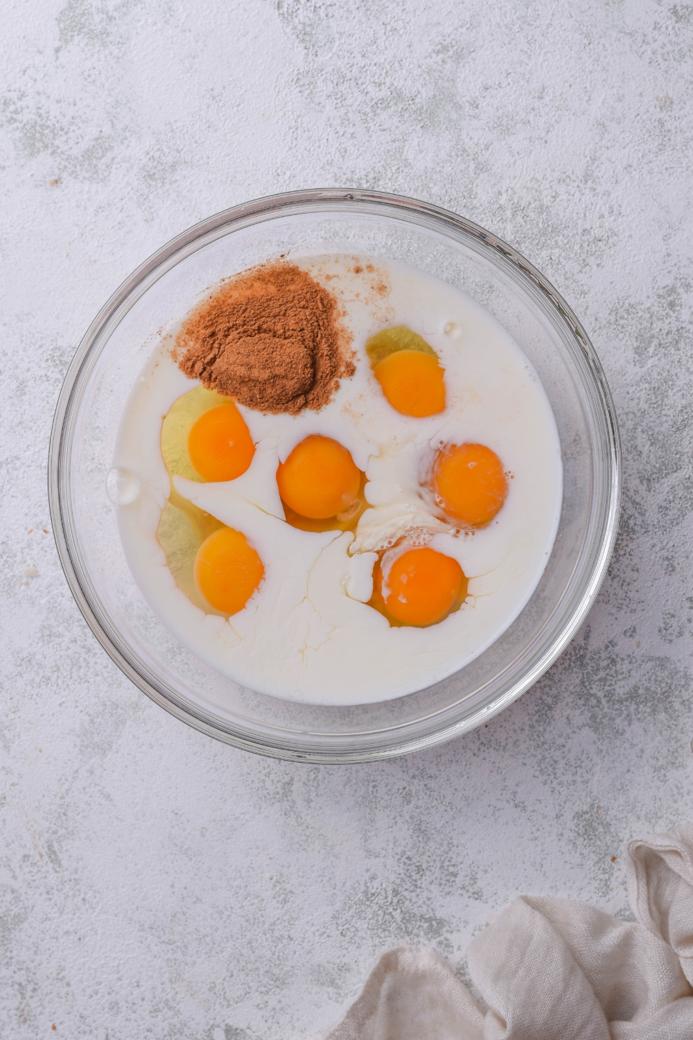 A mixing bowl with french toast egg mixture ingredients.