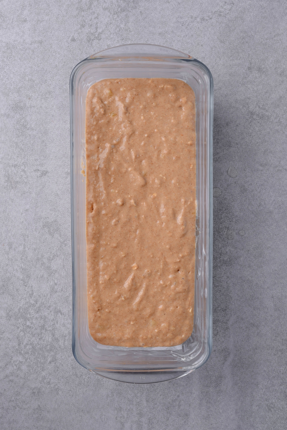 A loaf pan with banana bread batter in it.