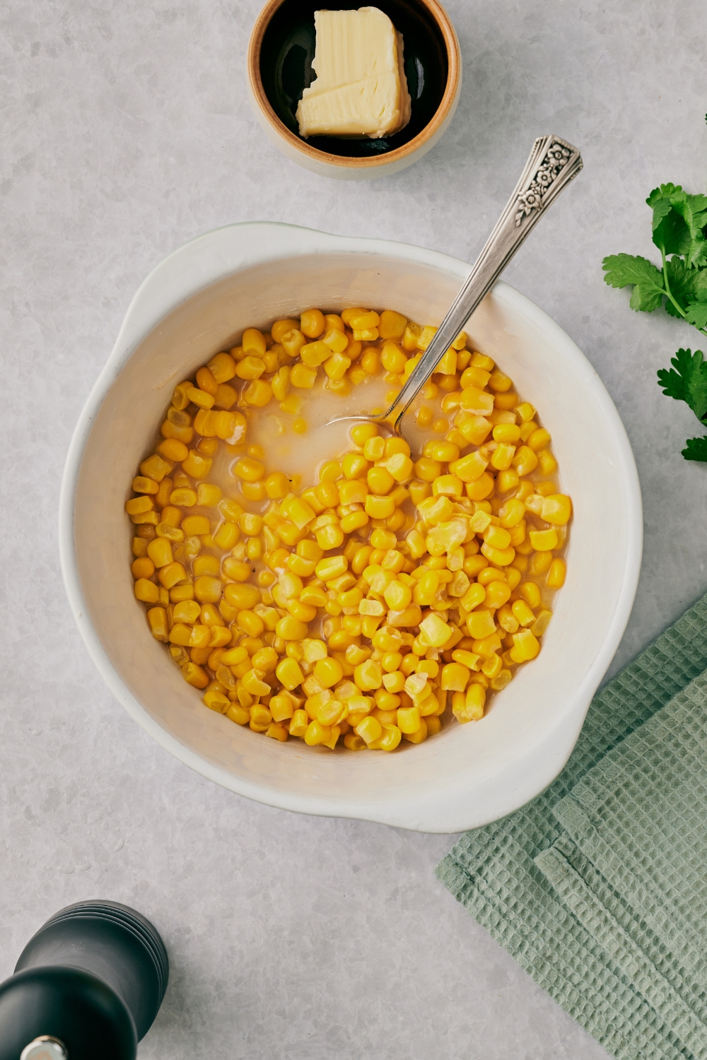 A mixing bowl with corn being mixed with all the ingredients.