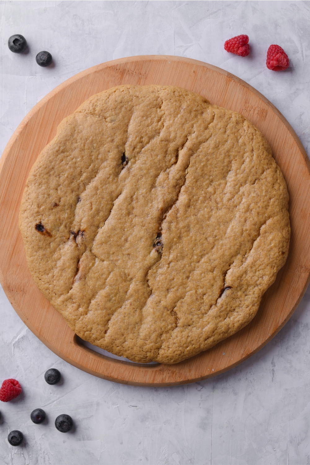 A wooden round tray with sugar cookie crust on it.