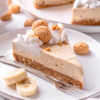 A slice of no bake banana pudding cheesecake on a white plate.