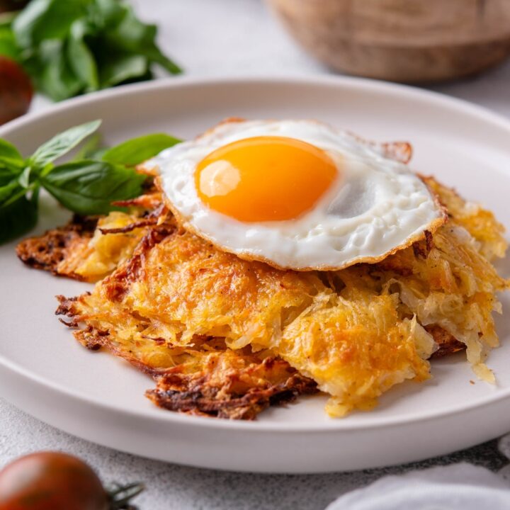 Plate with golden brown hash browns topped with a sunny side up egg.