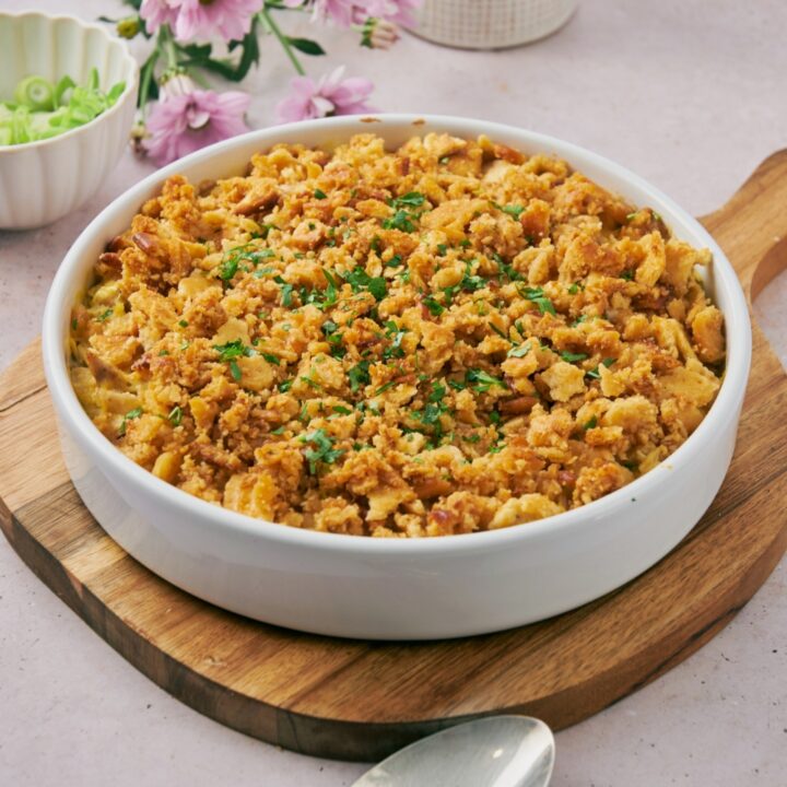 Freshly baked Ritz chicken casserole garnished with green herbs on a wooden board.